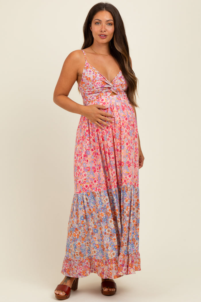 woman wearing a floral print maternity maxi dress with a v-neck and holding her baby bump