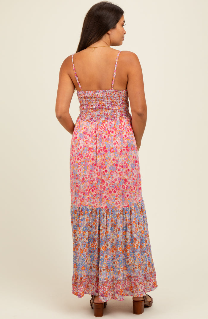 woman wearing a floral maternity maxi dress with a smocked bodice and tiered skirt, showing her baby bump from the back