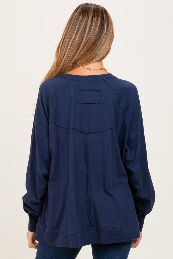 woman wearing a navy blue maternity top with long sleeves and a relaxed fit, viewed from the back