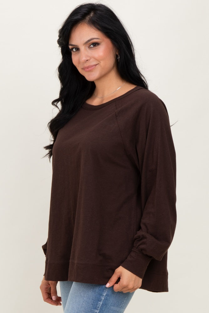 woman wearing a dark brown long sleeve oversized top with a relaxed fit and round neckline