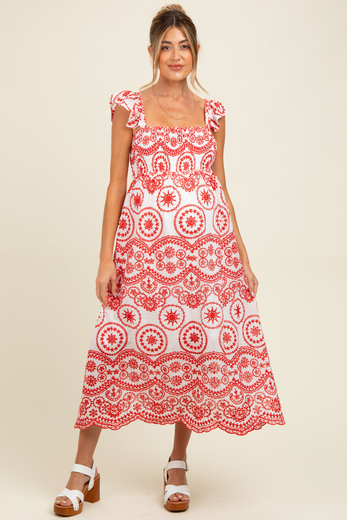 woman wearing a red and white patterned maternity dress with ruffled sleeves and a flowing skirt, baby bump visible