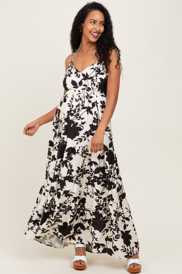 woman wearing a black and white floral maternity maxi dress with adjustable straps and a baby bump visible