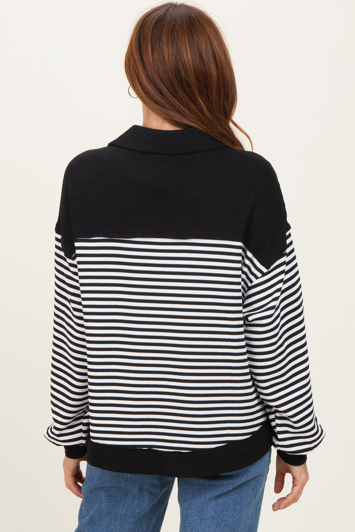woman wearing a black and white striped oversized pullover sweater, seen from the back