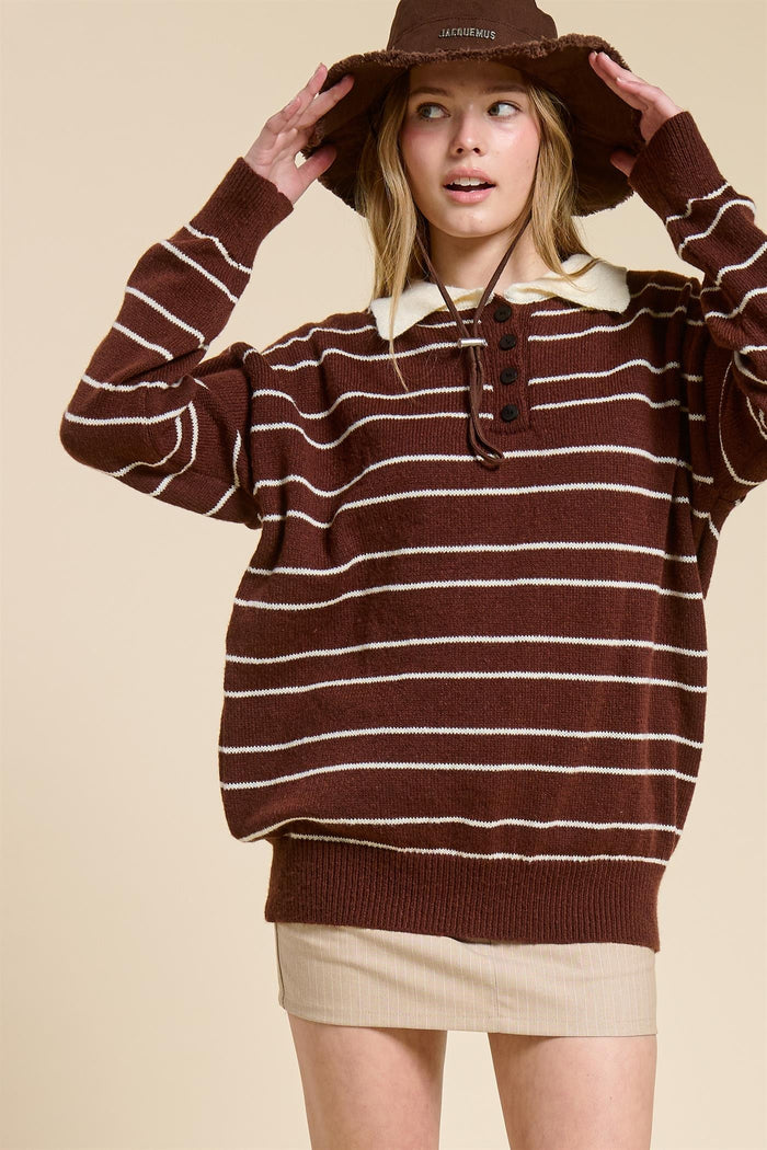 woman wearing a brown striped oversized sweater with a white collar and a beige mini skirt, paired with a brown hat