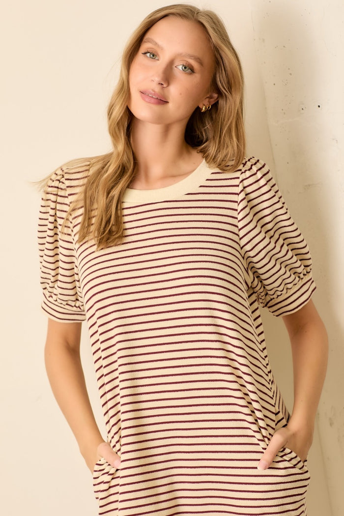woman wearing a striped knit top with puffed short sleeves and side pockets