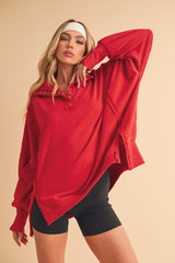 woman wearing a red oversized long sleeve top with button details and black bike shorts