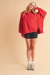 woman wearing an oversized red sweatshirt with a collar and black shorts, styled with white headband and sneakers