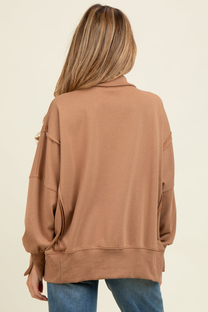 woman wearing a brown oversized maternity sweatshirt, styled with a relaxed fit and elevated neckline, seen from the back
