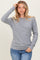 woman wearing a grey ribbed long sleeve top with rounded neckline and casual fit paired with blue jeans