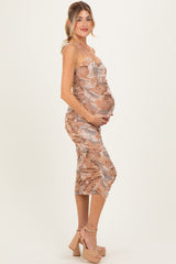 woman wearing a beige and brown printed maternity dress with ruching, showing off her baby bump