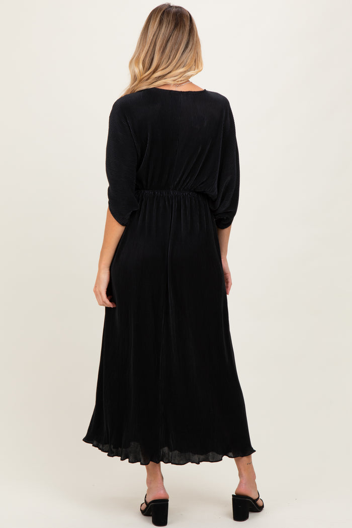 woman wearing a black maternity maxi dress with a cinched waist and long sleeves, showing a baby bump from the back