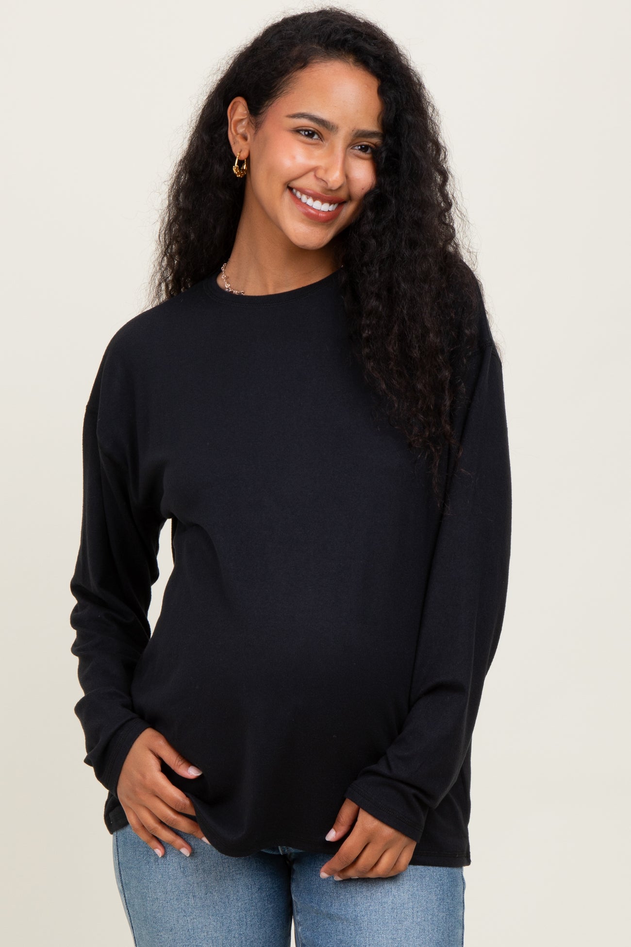 woman wearing a black long sleeve maternity top and showcasing her baby bump