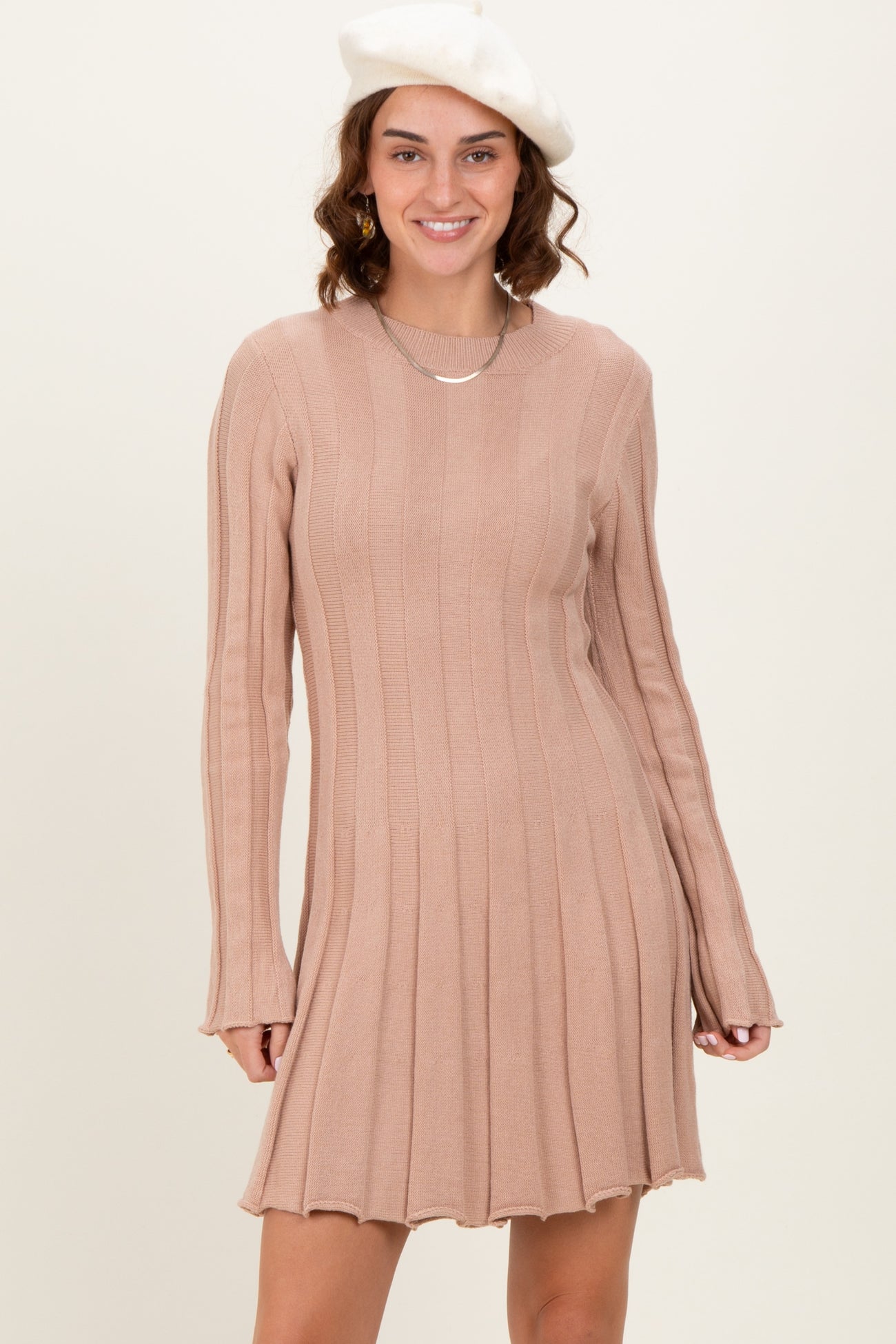 woman wearing a ribbed pink long sleeve dress with a flared hem and a beret