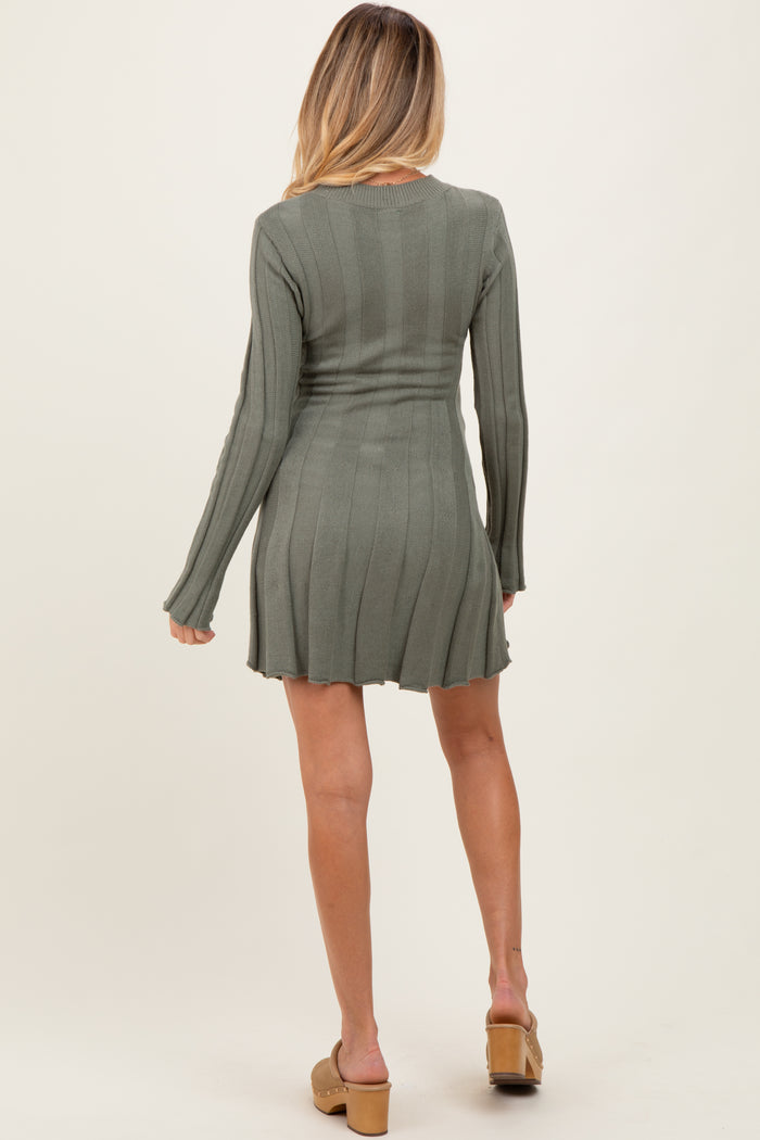 woman wearing a long sleeve olive green ribbed maternity dress with a fitted waist and flared skirt