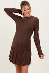 woman wearing a brown long sleeve knitted maternity dress with ribbed details and a visible baby bump