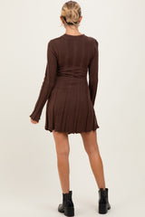 woman wearing a brown maternity ribbed sweater dress with long sleeves and a flared hem