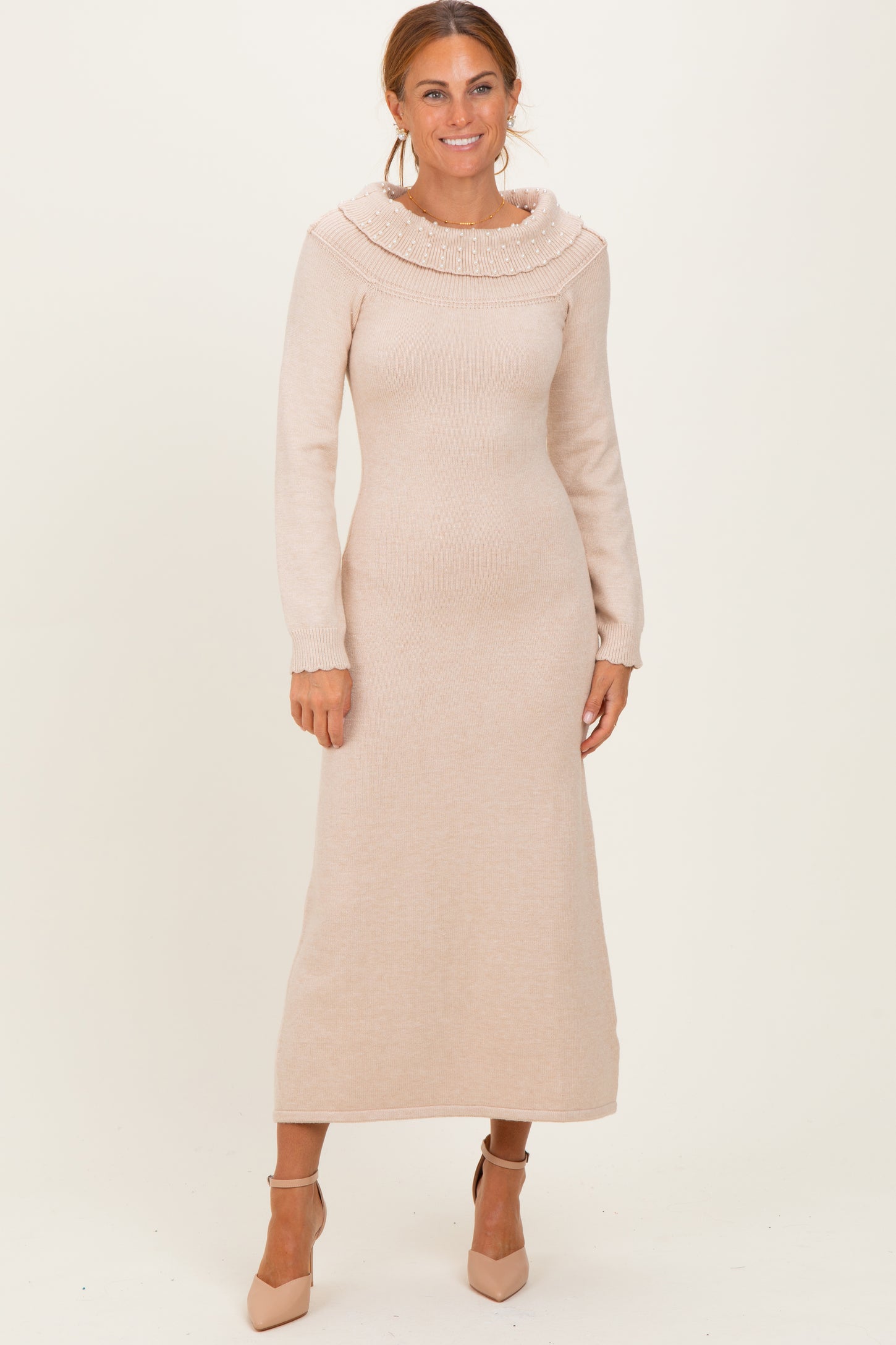 woman wearing a long sleeve light beige knit maxi dress with a decorative cowl neckline