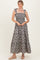 woman wearing a gray floral maxi dress with tie straps and a smocked bodice