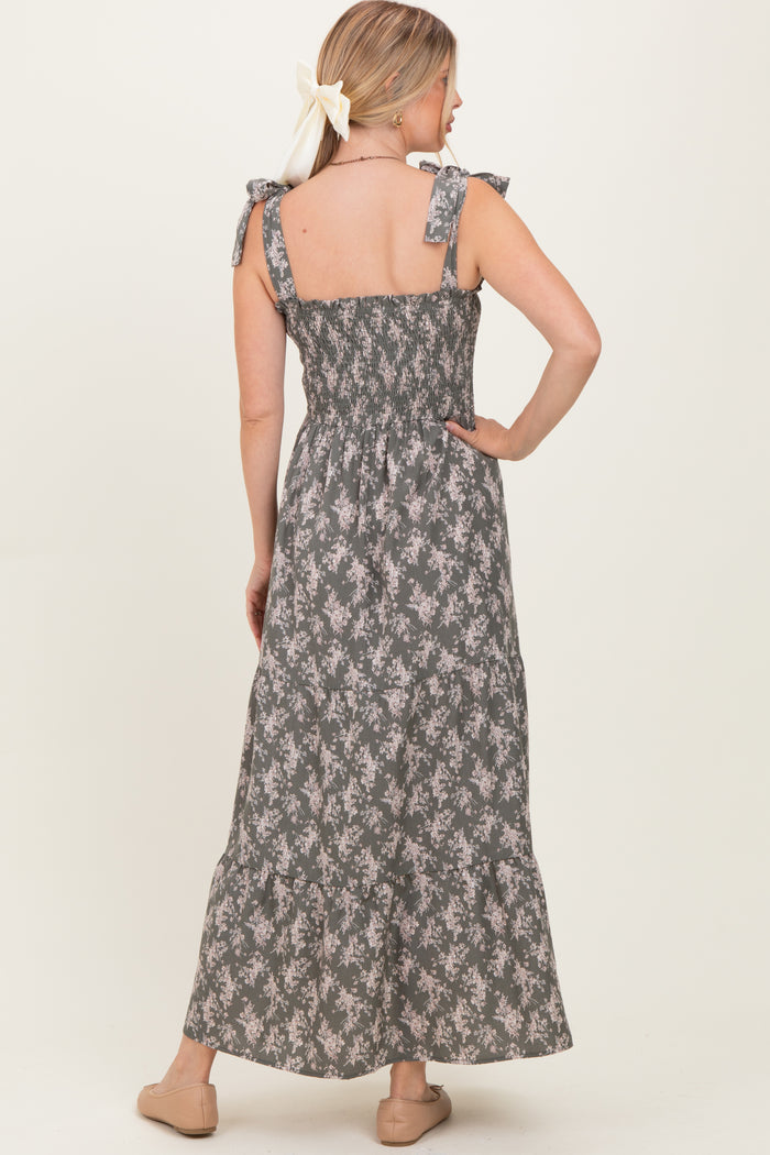 woman wearing a gray floral maxi dress with smocked back and bow tie straps