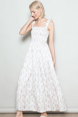 woman wearing a white floral maxi dress with ruffled straps and a smocked bodice