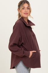 woman wearing a burgundy long sleeve maternity top with a collar and buttons, showing her baby bump
