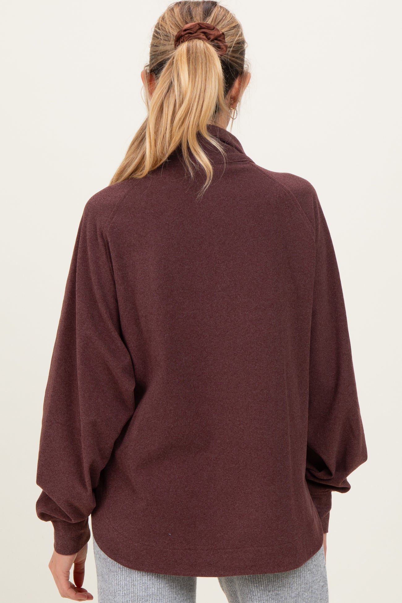 woman wearing a maroon maternity pullover with a relaxed fit and long sleeves, shown from the back