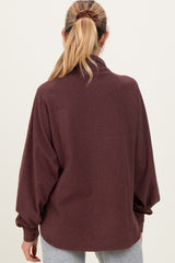 woman wearing a maroon maternity pullover with a relaxed fit and long sleeves, shown from the back