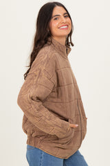 woman wearing a brown quilted zip-up jacket with side pockets and a high collar