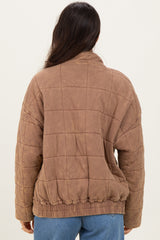 woman wearing a brown quilted jacket with a cinched waist and back view.