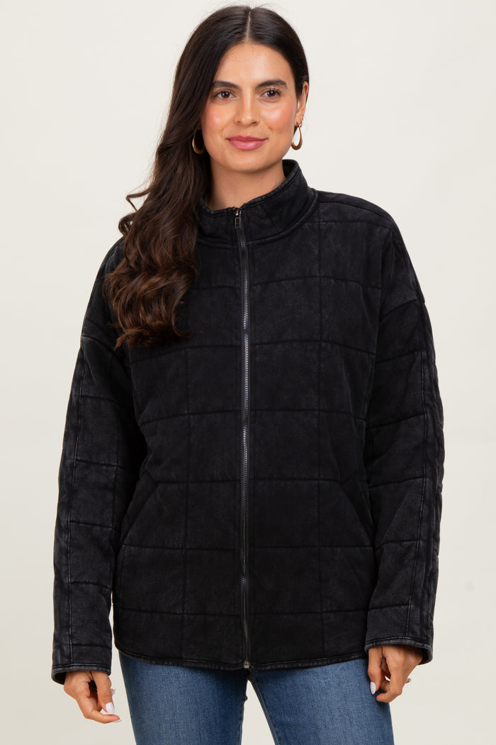 woman wearing a black quilted zip-up jacket with a high collar and long sleeves