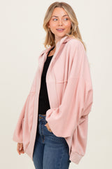 woman wearing a soft pink oversized cardigan with a hood and dropped shoulders, paired with a black top and jeans