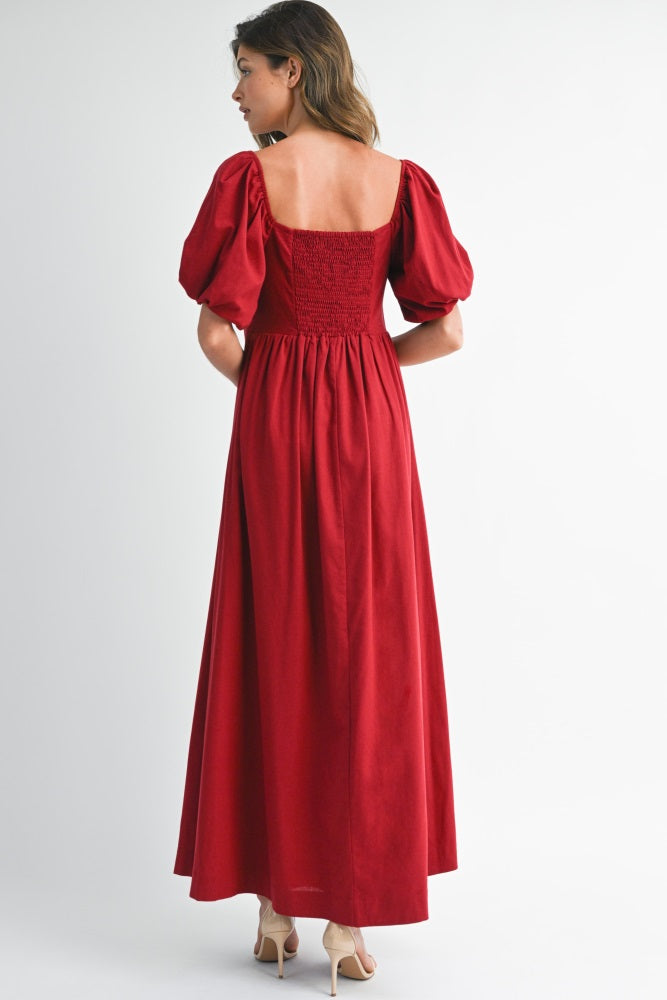 woman wearing a red maxi dress with puff sleeves and a smocked back detailing
