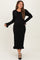 woman wearing a black maternity ribbed dress with a tie neck and ruffle hem, highlighting her baby bump