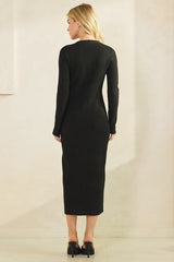 woman wearing a form-fitting black ribbed knit maxi dress with long sleeves and back detail