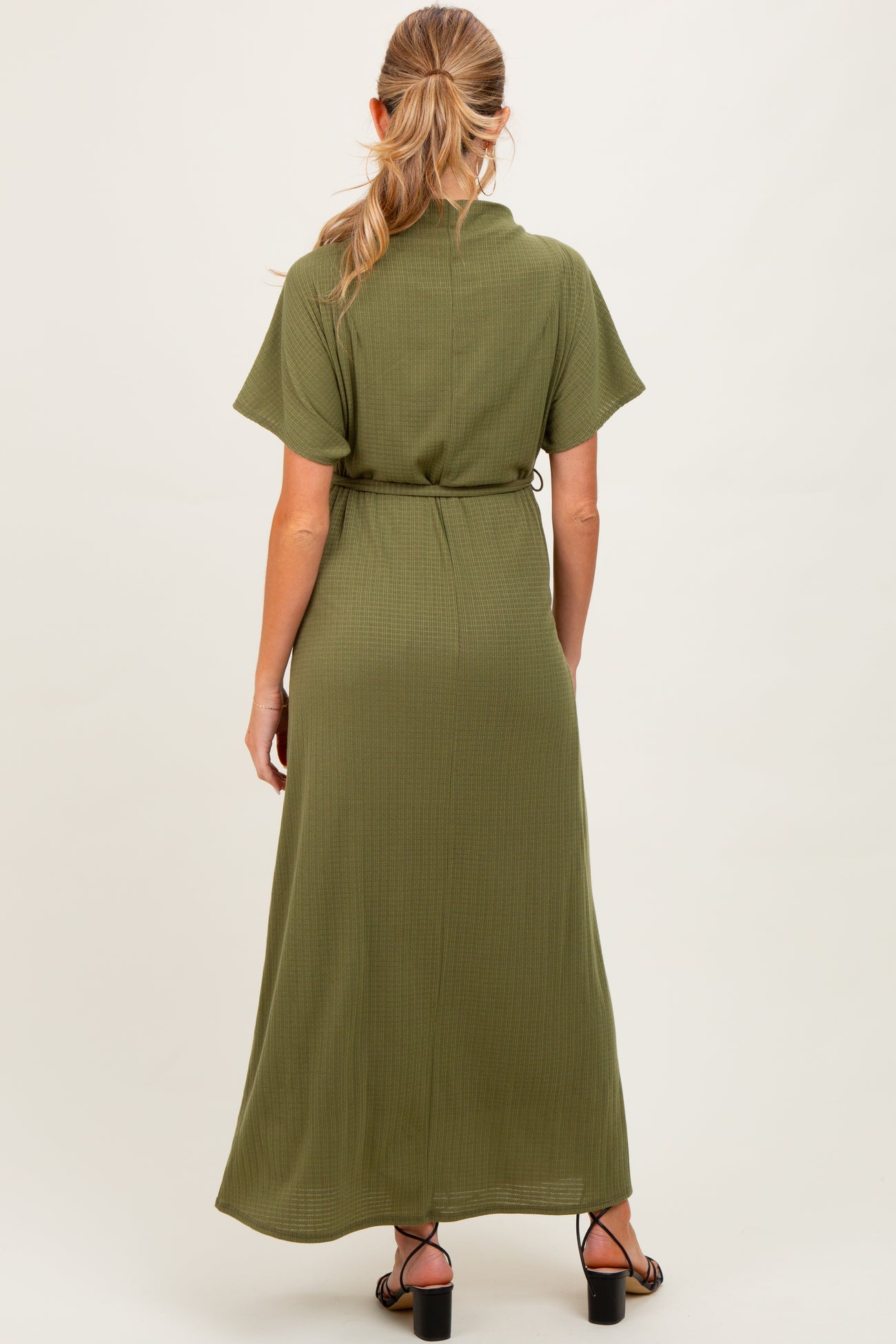 woman wearing an olive green maternity maxi dress with short sleeves and a tie waist detail.
