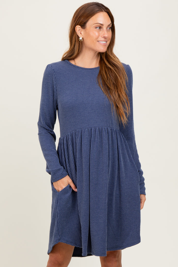 woman wearing a navy blue long sleeve ribbed dress with pockets and a relaxed fit