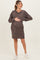 woman wearing a brown animal print maternity dress and holding her baby bump