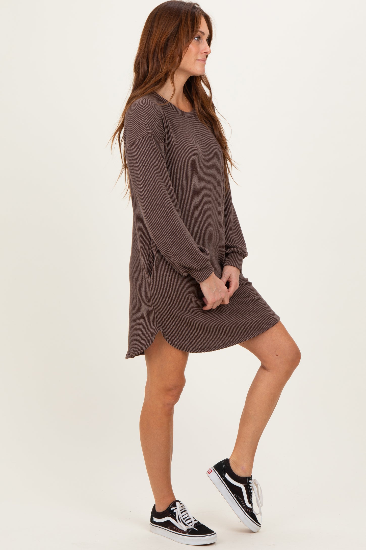 woman wearing a brown ribbed long sleeve dress with side pockets and a relaxed fit