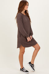 woman wearing a brown ribbed long sleeve dress with side pockets and a relaxed fit