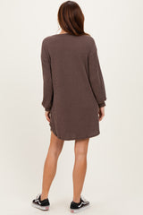 woman wearing a brown striped long sleeve mini dress, shown from the back, paired with black sneakers