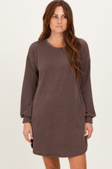woman wearing a brown ribbed long sleeve oversized dress with a round neckline