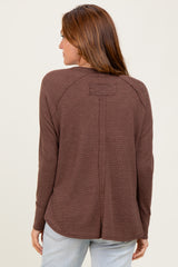 woman wearing a brown long sleeve top with a relaxed fit and a back seam detail