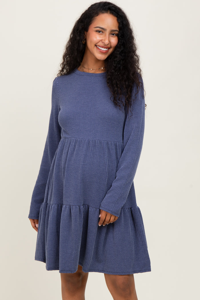 woman wearing a navy ribbed long sleeve maternity dress with a tiered skirt and a relaxed fit