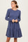woman wearing a navy ribbed long sleeve dress with a tiered ruffle hem