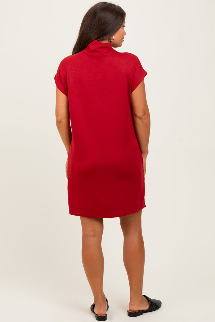 woman wearing a short sleeve red maternity dress with a high collar, viewed from the back