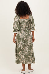 woman wearing an olive green floral midi dress with puff sleeves and a fitted bodice, shown from the back