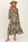 woman wearing a floral print olive green maternity dress with long sleeves and a flowy skirt, accessorized with a hat