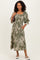 woman wearing an olive green floral maxi dress with puff sleeves and a tie detail, holding a handbag
