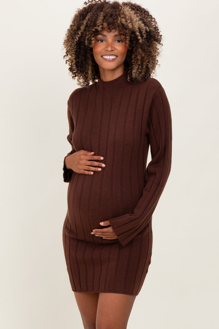 woman wearing a chocolate brown ribbed maternity dress with long sleeves and holding her baby bump