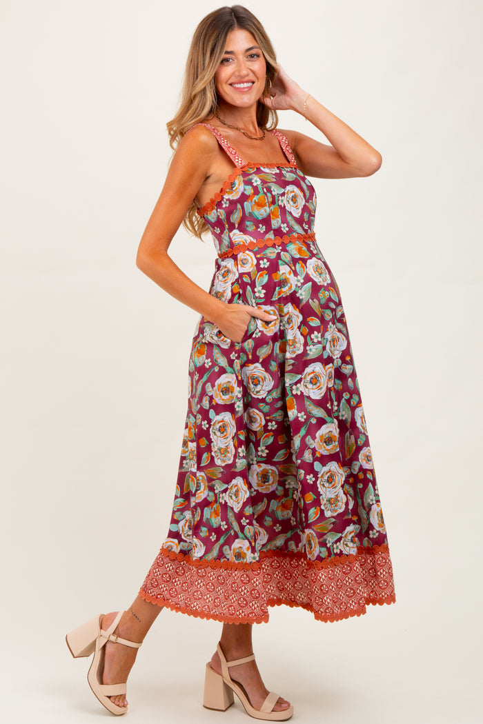woman wearing a floral maternity maxi dress with pockets and ruffled hem, showing her baby bump